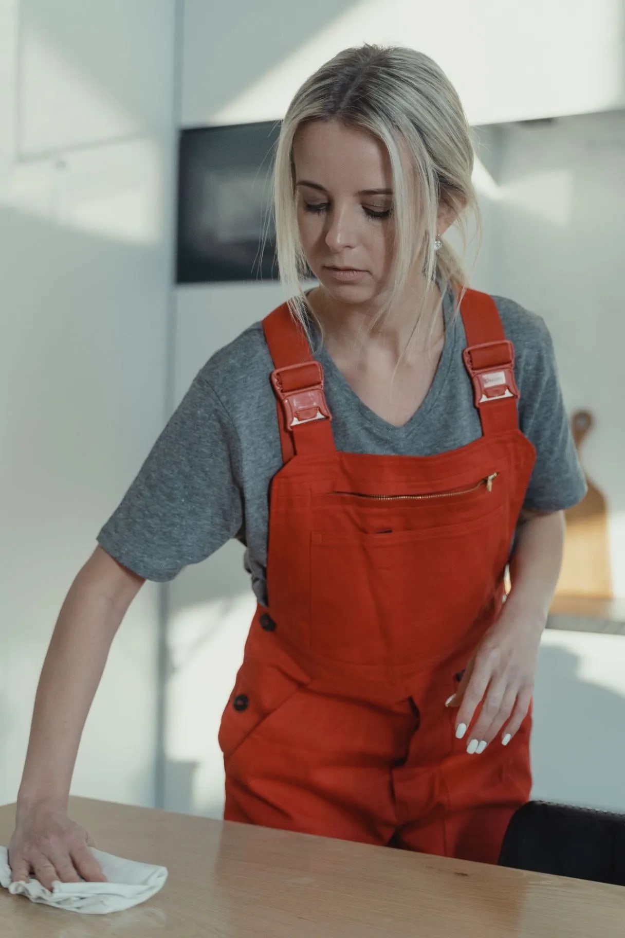 Woman in an apron wiping down a table