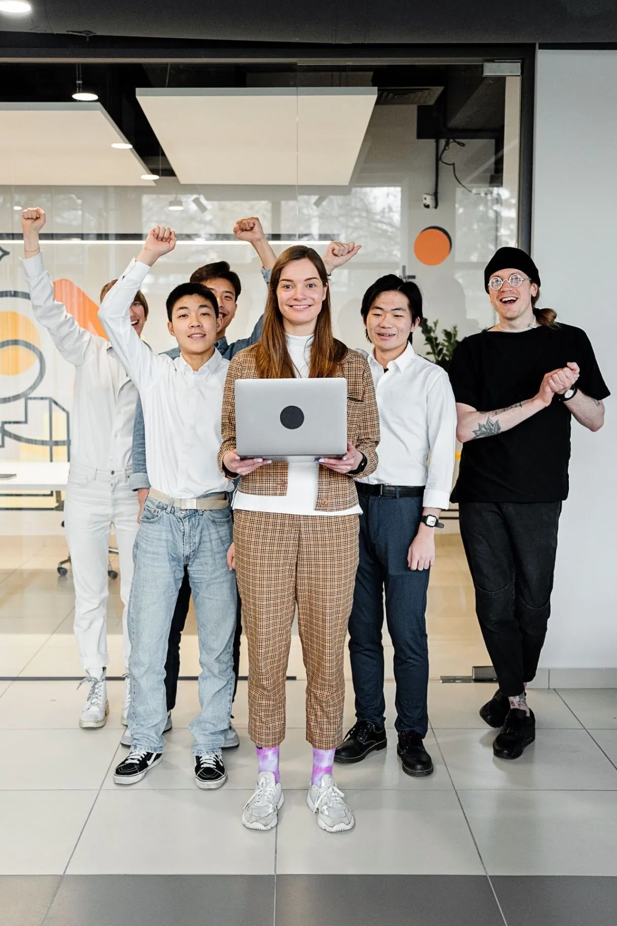 Happy team celebrating together with a laptop